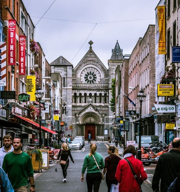 A bustling street scene in Dublin, showcasing diverse people and historic architecture.