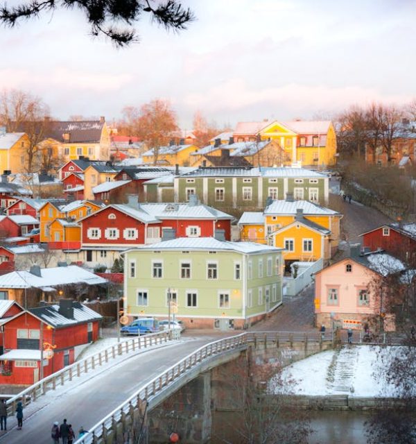 Captivating winter scene of colorful houses in Porvoo, Finland viewed from a bridge.