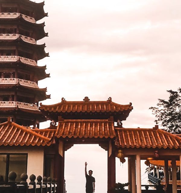 Stunning view of Chin Swee Caves Temple's pagoda during sunset with a lone figure standing underneath.